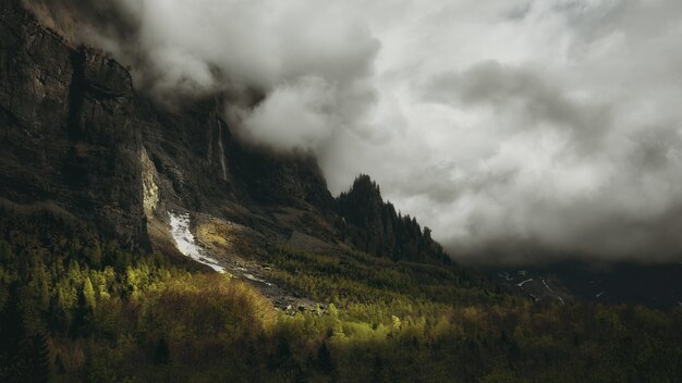 Hoge berg bedekt met witte dikke wolken