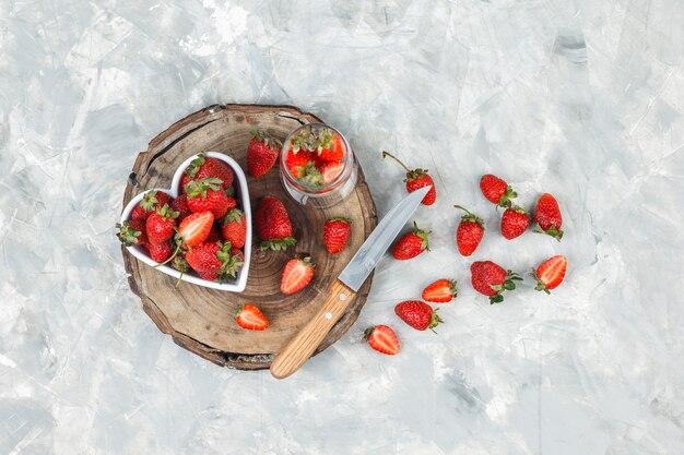 Hoge hoek bekijken een kom aardbeien op ronde rieten placemat op donkerblauw marmeren oppervlak. horizontaal