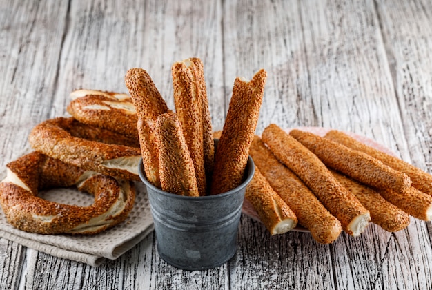 Gratis foto hoge hoek bekijken turkse bagel met een kopje thee en brood op houten oppervlak. horizontaal