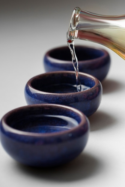 Gratis foto hoge hoek blauwe kopjes met sake drankje