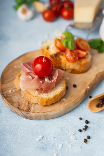 Hoge hoek bruschettas met prosciutto en tomaten