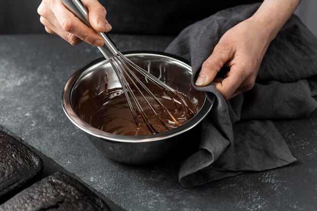 Hoge hoek die van banketbakker chocoladetaart voorbereidt