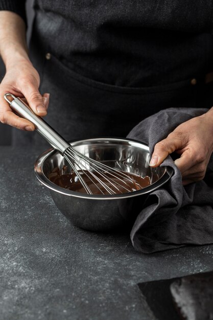 Hoge hoek die van chef-kok chocoladetaart voorbereidt
