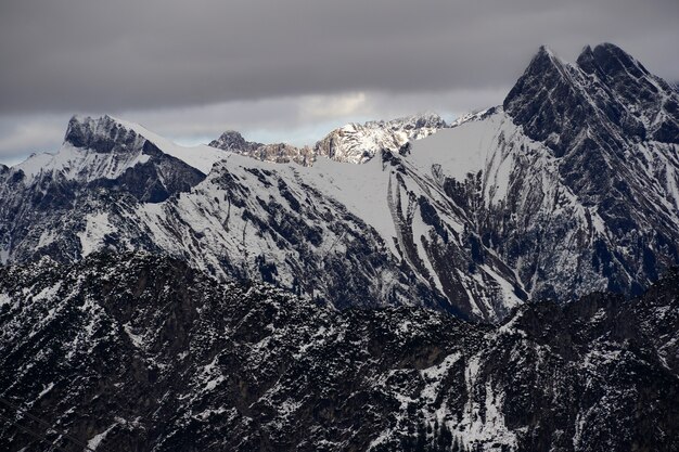 Hoge hoek die van de Alpiene bergketen onder de bewolkte hemel is ontsproten