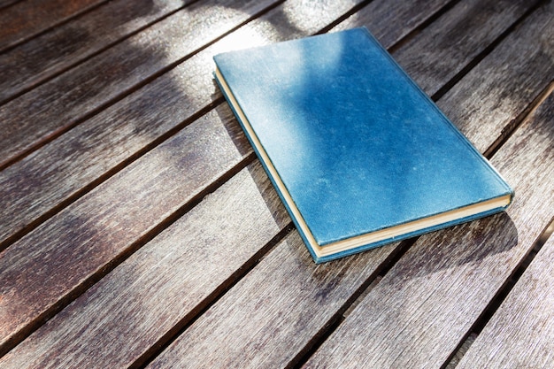 Hoge hoek die van een blauw boek op een houten oppervlakte is ontsproten