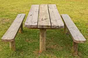 Gratis foto hoge hoek die van een houten tafel en banken op het gras behandelde gebied is ontsproten