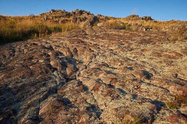 Hoge hoek die van een rotsoppervlak is ontsproten met een prachtig landschap van zonsondergang in een heldere blauwe hemel