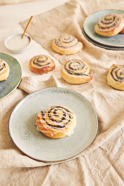 Hoge hoek die van heerlijke papaverzaadbroodjes met een suikerglans op een lijst is ontsproten