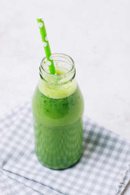 Hoge hoek groene smoothie met groen stro