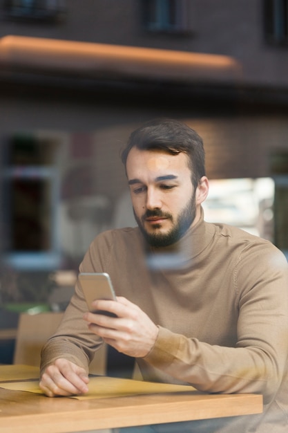 Hoge hoek jonge ondernemer mobiel kijken