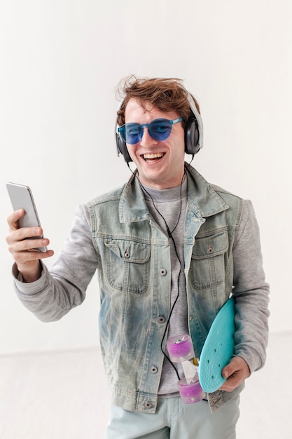 Hoge hoek jongen met skateboard luisteren muziek