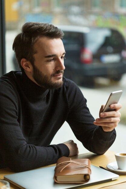 Hoge hoek knappe man telefoon kijken