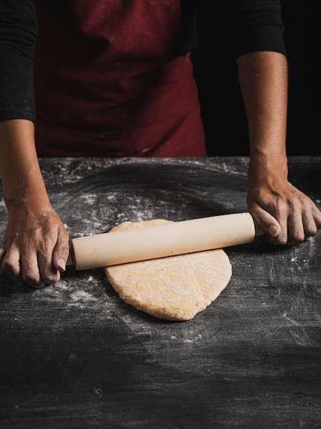 Gratis foto hoge hoek kneden van deeg met roller