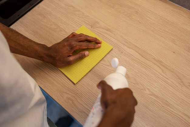 Hoge hoek man schoonmaaktafel