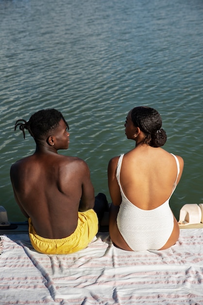 Gratis foto hoge hoek mensen zitten bij het meer