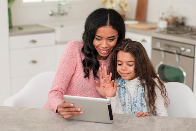 Hoge hoek moeder en dochter met behulp van tablet