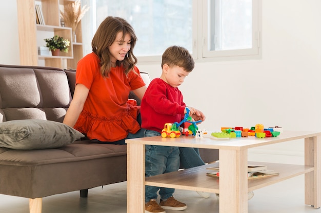 Hoge hoek moeder kijken zoon tijdens het spelen