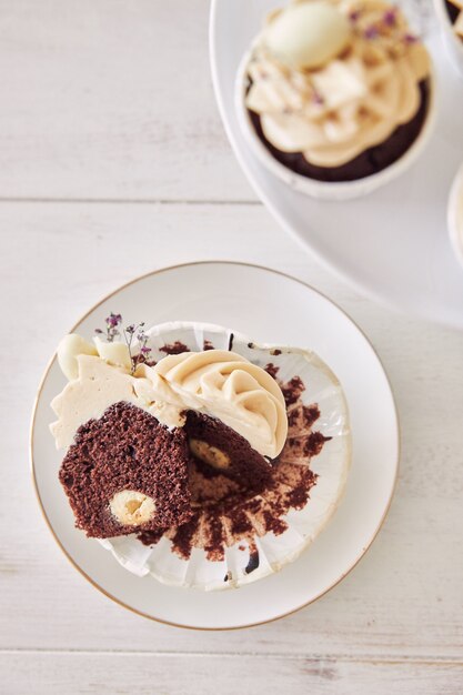 Hoge hoek opname van heerlijke chocolade cupcake met witte crème topping