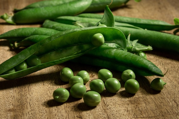 Gratis foto hoge hoek opname van verse groene erwten op de houten tafel