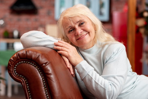 Hoge hoek oudere vrouw zittend op de bank