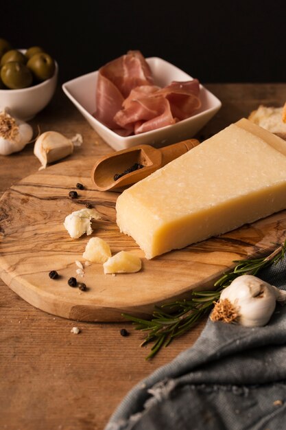 Hoge hoek Parmezaanse kaas en prosciutto op snijplank