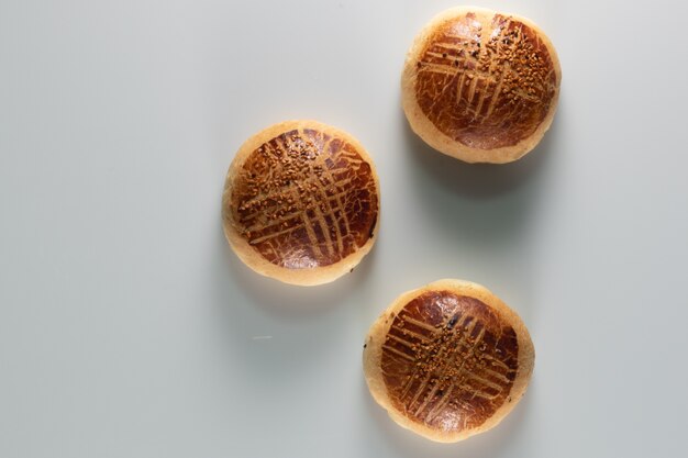 Hoge hoek shot van drie vers gebakken zoete broodjes op een witte ondergrond