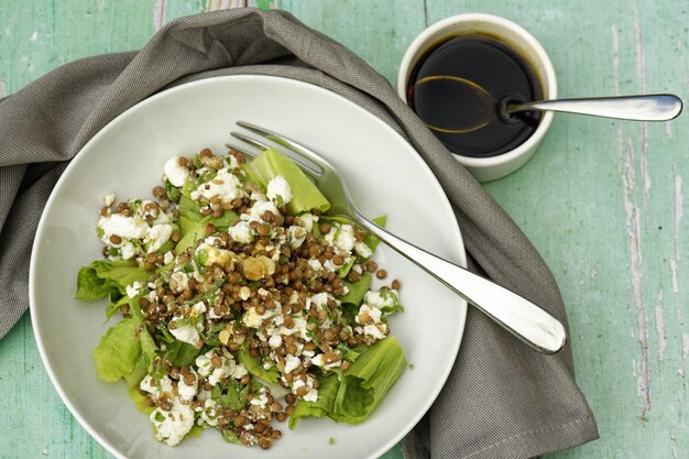 Hoge hoek shot van linzen en feta salade met balsamico dressing en vork