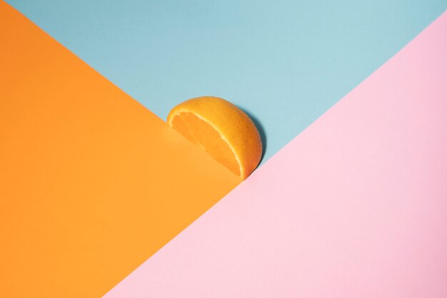 Hoge hoek sinaasappelschijfje en kleurrijke achtergrond