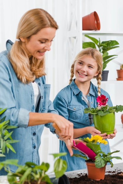 Hoge hoek smiley moeder en dochter planten van bloemen