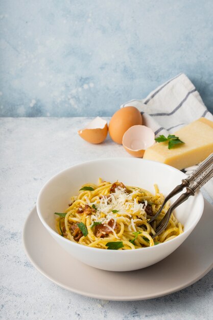 Hoge hoek spaghetti kom met parmezaanse kaas en eieren