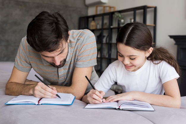 Hoge hoek vader en meisje schrijven