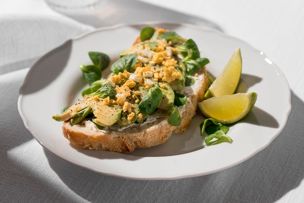 Hoge hoek van avocadotoost op plaat met limoenen (lemmetjes)