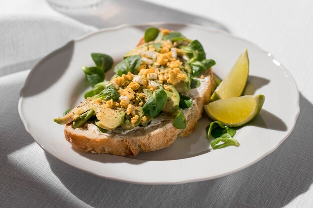 Hoge hoek van avocadotoost op plaat met limoenen (lemmetjes)