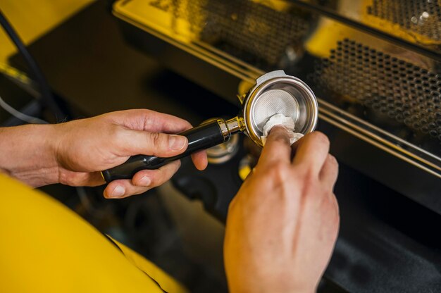 Hoge hoek van barista reinigingsbeker voor koffiezetapparaat