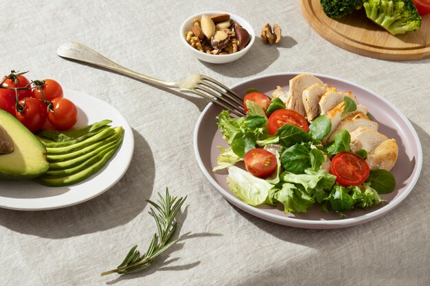Hoge hoek van bord met keto-dieetvoedsel en een bord met gesneden avocado