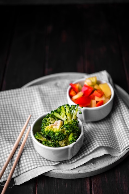 Hoge hoek van broccoli en paprika in kopjes op plaat