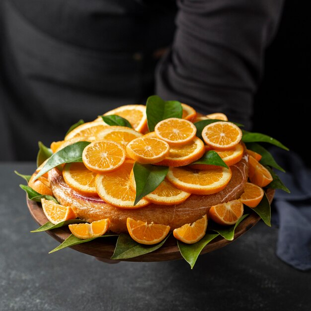 Hoge hoek van cake met stukjes sinaasappel en bladeren