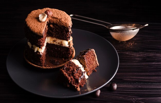 Hoge hoek van cake met uitgesneden plakje en zeef