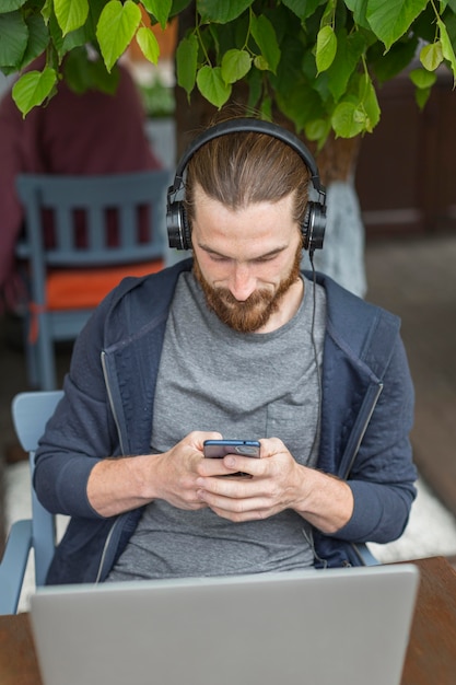 Gratis foto hoge hoek van de mens op een stadsterras met laptop en smartphone