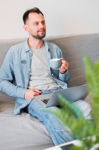 Hoge hoek van de mens wotking op zijn laptop