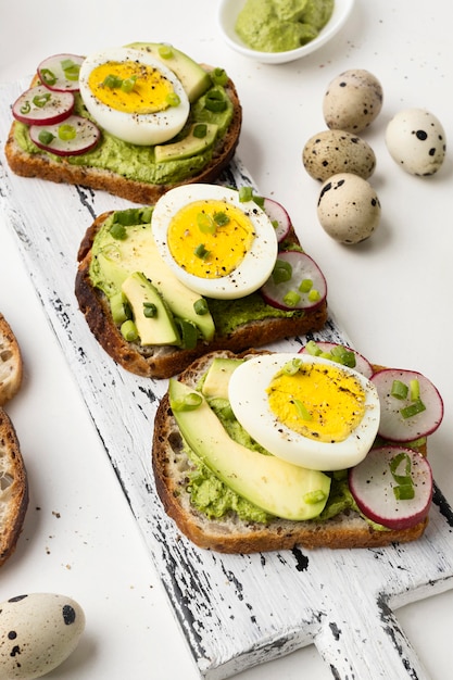 Hoge hoek van heerlijke sandwiches met eieren en avocado