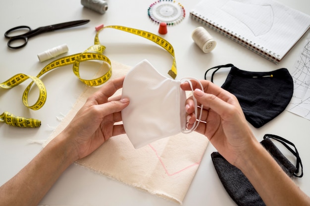 Hoge hoek van het gezichtsmasker van de vrouwenholding dat zij heeft genaaid