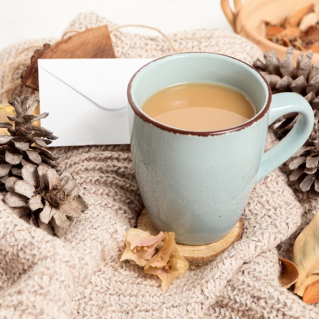 Hoge hoek van koffiemok met dennenappels en herfstbladeren