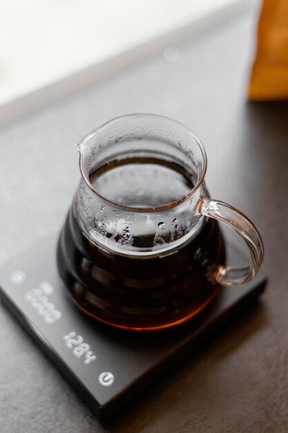 Hoge hoek van kruik met koffie op schaal in de coffeeshop
