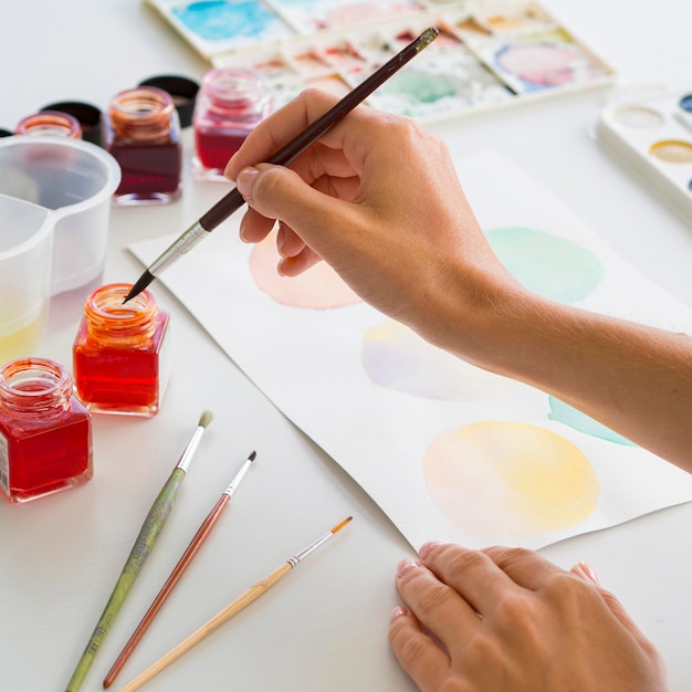 Hoge hoek van kunstenaar schilderen met behulp van aquarel