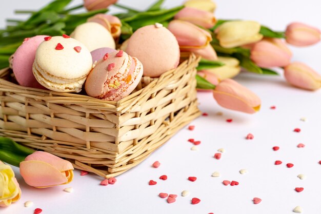 Hoge hoek van mand met macarons en tulpen voor Valentijnsdag