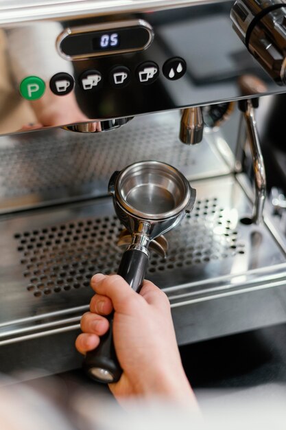 Hoge hoek van mannelijke barista met koffiemachine