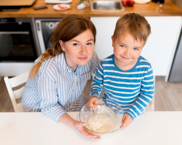 Hoge hoek van moeder en zoon koken