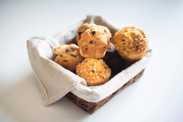 Hoge hoek van muffins in mand op effen achtergrond