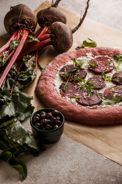 Hoge hoek van pizzadeeg met plakjes kaas en bieten